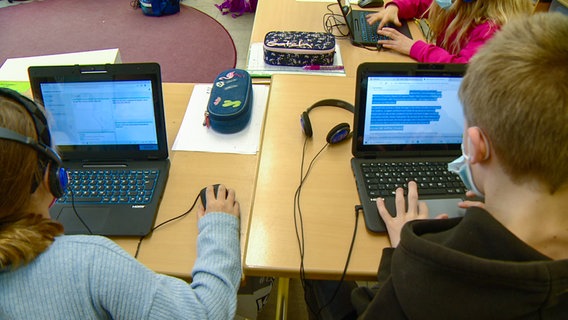 Zwei Grundschüler arbeiten an Laptops während eines Unterrichst an der Grundschule in Oelixdorf. © NDR 