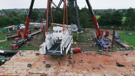 Der Neubau der Rendsburger Schwebefähre wird auf das Kanalufer verladen. © NDR 