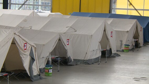 Mehrere Zelte stehen in einer Erstaufnahmestelle für Geflüchtete.  