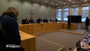 Mehrere Richter sitzen an einem Tisch in einem Verhandlungsraum. © NDR 