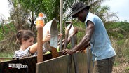 Mehrere Menschen bauen in Ghana ein Lehmhaus. © NDR 