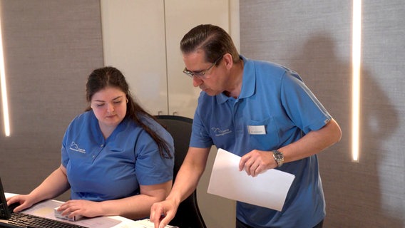 Lungenfacharzt Dr. Tahsin Balli und dessen Praxismanagerin Katrin Schidkow tauschen sich bei der Arbeit aus. © NDR Foto: NDR Screenshot