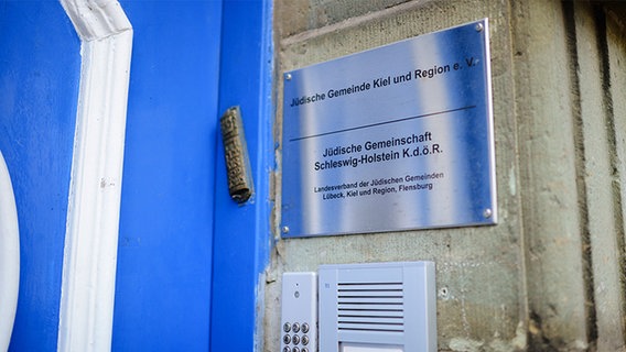 Ein Schild am Gebäude der der Jüdischen Gemeinde Kiel und Region e.V., rechts neben der hellblauen Eingangstür. © NDR Foto: Lisa Pandelaki