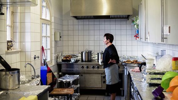 Eine Frau steht in einer Küche, die mit Alufolie ausgekleidet ist. © NDR Foto: Lisa Pandelaki