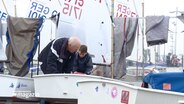 Olympionik Heinz Laprell und sein Enkel Korbinian Grawe stehen an einem Segelboot. © NDR 