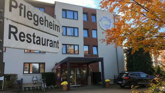 Zwei Wegweiser mit den Überschiften "Pflegeheim" und "Restaurant" zeigen in Richtung des Seniorenheims Haus Hog'n Dor in Norderstedt. © NDR Foto: Helge Albrecht