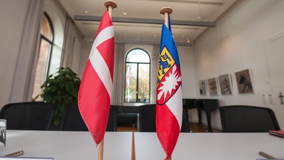 Die Flagge von Dänemark und von Schleswig-Holstein auf einem Tisch. © picture alliance / Caro | Ruff Foto: Caro Ruff
