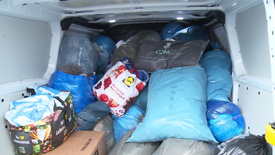 Hilfsgüter liegen in Plastiksäcken verpackt in einem Kofferraum eines Transporters © NDR 