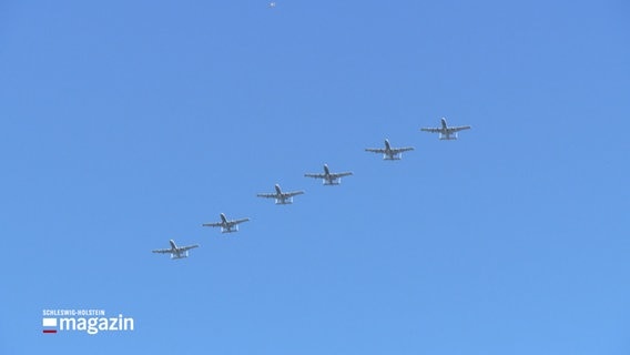 Sechs Flugzeuge fliegen in einer Formation am wolkenlosen Himmel. © NDR Foto: NDR Screenshots