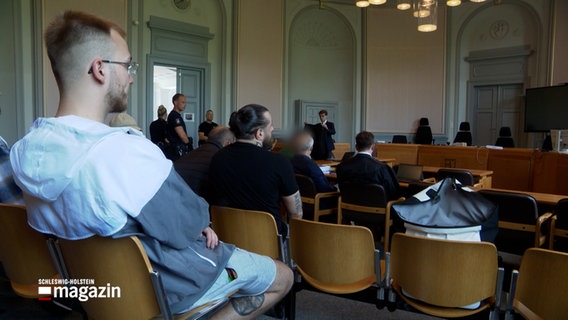 Ein Angeklagter (rechts) sitzt neben seinem Verteidiger in einem Gerichtssaal © NDR 