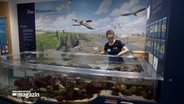 Eine Mitarbeiterin reinigt ein Aquarium in einem Museum über das Wattenmeer. © NDR Foto: NDR Screenshots