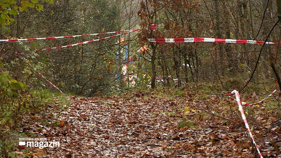 Ein Stück eines Weges ist mit rot-weißen Flatterband abgesperrt. © NDR Foto: NDR Screenshot
