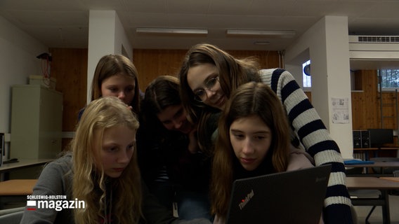 Schülerinnen der 7. und 8. Klasse sitzen um einen Laptop herum © NDR Foto: NDR Screenshot
