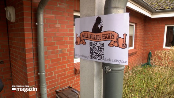 Ein Plakat verweist mit einem QR-Code auf eine digitale Schnitzeljagd durch den Ort Willingrade © NDR Foto: NDR Screenshot
