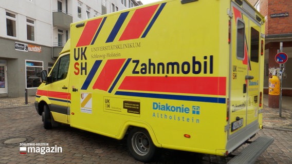 Ein Fahrzeug, das einem Rettungswagen ähnelt, mit der Aufschrift "Zahnmobil" fährt durch eine Straße. © NDR Foto: NDR Screenshot