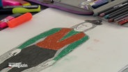 Eine von einem Kind bemalte Zeichnung eines Mannes zeigt diesen in einem Grünen Oberteil mit einer braunen Weste. © NDR Foto: NDR Screenshot