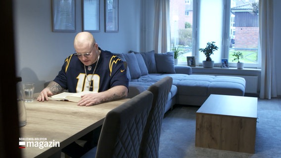 Ein Mann liest in einem Buch © NDR Foto: NDR Screenshot