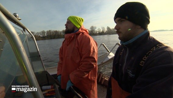 Zwei Stint-Fischer stehen auf einem Boot © NDR Foto: NDR Screenshot