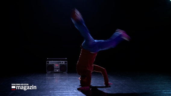 Ein Breakdancer tanzt in einem Studio auf seinem Kopf © NDR Foto: NDR Screenshot