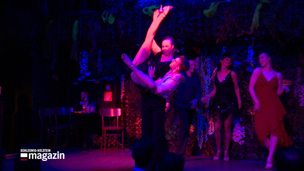 Während einer Tanzaufführung wird eine Frau von einem Tanzpartner in die Luft gehoben