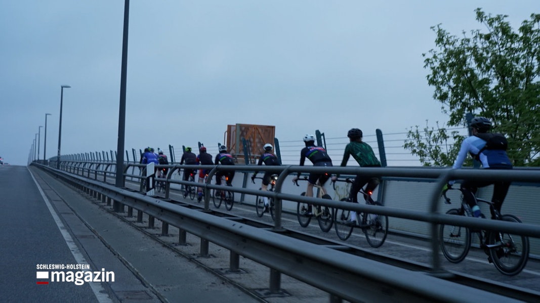 Mehrere Radfahrer fahren auf einer Brücke