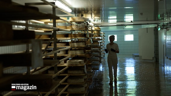 Eine Person geht durch einen Lagerraum für Käse © NDR Foto: NDR Screenshot