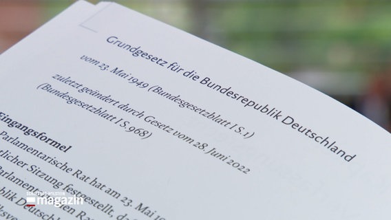 Ein Gesetzestext des Grundgesetzes der Bundesrepublik Deutschland wird in die Kamera gehalten © NDR Foto: NDR Screenshot
