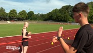 Ein junger Mann erklärt auf einem Sportplatz eine Sportübung © NDR Foto: NDR Screenshot