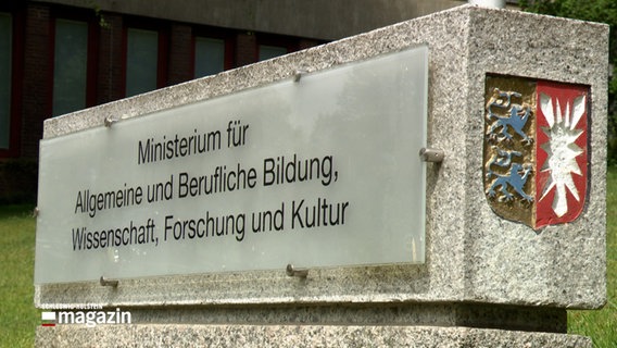Ein Stein mit einer Glasplatte vor dem Ministerium für Allgemeine und Berufliche Bildung, WIssenschaft, Forschung und Kultur © NDR Foto: NDR Screenshot
