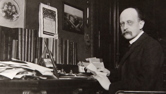 Eine historische Aufnahme von Max Planck an einem Schreibtisch. © NDR 