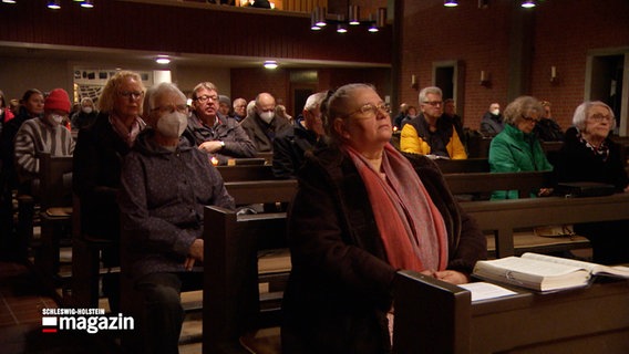 Menschen sitzen während einer Andacht in einer Kirche © NDR Screenshot 