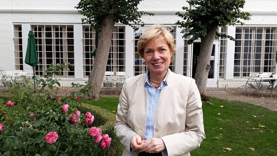 Ulrike-Wolff Thomsen steht in einem Vorgarten und lächelt in die Kamera. © NDR Foto: Svenja Lanz