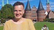 Ein Mann steht vor dem Holstentor in Lübeck. Es ist Christian Martin Lukas, der Tourismus-Chef von Lübeck und Travemünde. © NDR Foto: Mechthild Mäsker