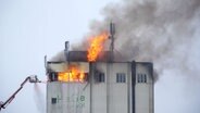 Ein Getreidesilo in Brunstorf steht in Vollbrand und wird von Einsatzkräften der Feuerwehr mit einem Kran gelöscht © dpa-Bildfunk Foto:  Daniel Bockwoldt