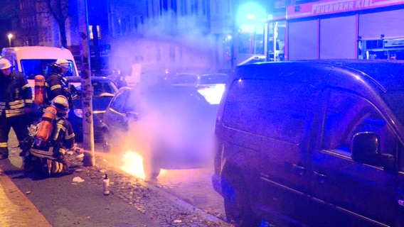 Einsatzkräfte der Feuerwehr löschen ein brennendes Auto in Kiel Gaarden. © NDR 