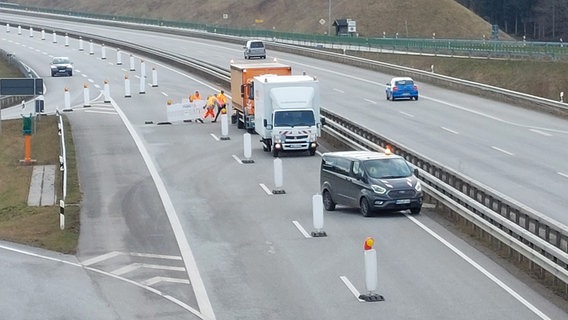 Arbeiter räumen Absperrungen von einer Straße in einen Pritschenwagen. © NDR Foto: Balthasar Hümbs