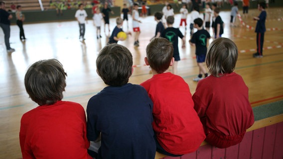 Kinder schauen beim Voelkerballspiel in einer Turnhalle zu. © IMAGO Foto: Frank Sorge