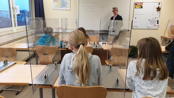 Ein volles Klassenzimmer, in dem die Sitzplätze mit Spuckschützen separiert sind. © Johannes Tran Foto: Johannes Tran