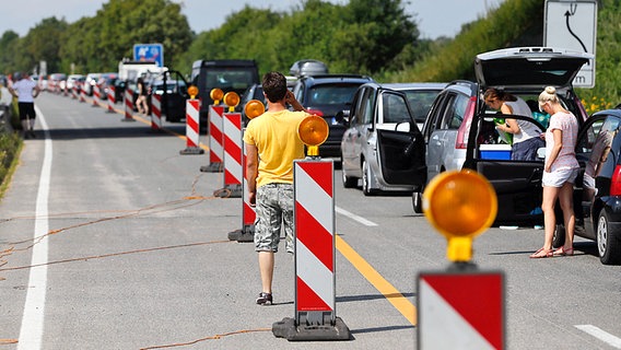 Autofahrer stehen auf der A 23 bei Elmshorn im Stau. Einige sind aus ihrem Wagen ausgestiegen © dpa - Bildfunk Foto: Axel Heimken