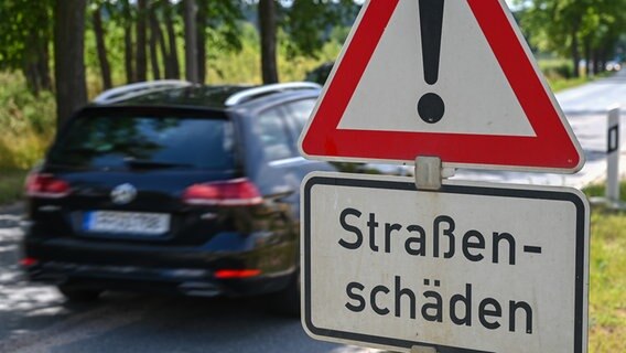 Ein Straßenschild weist auf Schäden der Fahrbahn hin © picture alliance Foto: Patrick Pleul