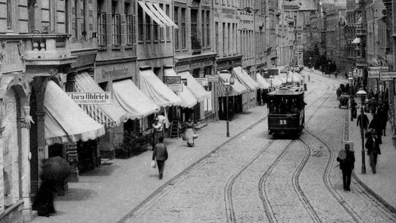 Eine sehr alte Aufnahme zeigt eine Lübecker Straßenbahn in der Innenstadt. © Fotoarchiv der Hansestadt Lübeck 