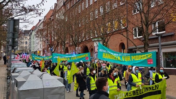 Streikende des UKSH laufen durch die Straßen in Kiel und halten dabei Banner und Fahnen hoch. © NDR Foto: Kevin Bieler
