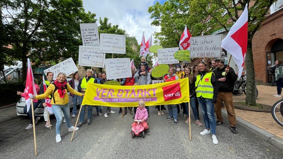 Menschen halten bei einer Demonstration verschiedene Plakate hoch. Auf einem davon steht "Ver.Stärkt Sozial- und Erziehungsberufe". © NDR Foto: Christian Wolf