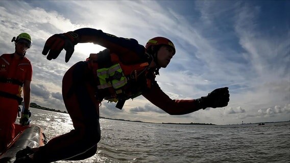 DLRG-Retter Levke Tamm springt ins Wasser. © NDR Foto: Levin Laske