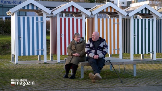 Eine Frau und ein Mann sitzen auf einer Bank an der Kiellinie. © NDR 