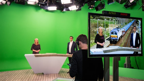 Zwei Fernsehmoderatoren stehen in einem digitalen Studio vor einem grünen Hintergrund. © NDR Foto: Janis Röhlig