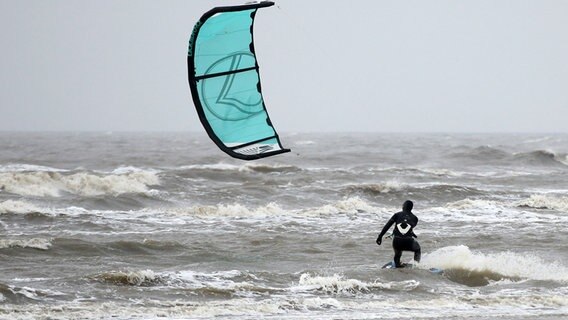 Ein Kitesurfer ist bei stürmischem Wetter auf der Nordsee in St. Peter-Ording unterwegs © picture alliance / dpa | Bodo Marks Foto: Bodo Marks