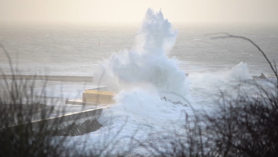 Wassermassen prallen auf Wellenbrecher auf Helgoland und erzeugen dabei meterhohe Gischt. © NDR 