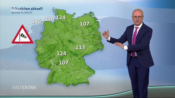 Ein TV-Moderator zeigt auf eine eingeblendete Wetterkarte mit Windgeschwindigkeiten über Europa. © ARD EXTRA 