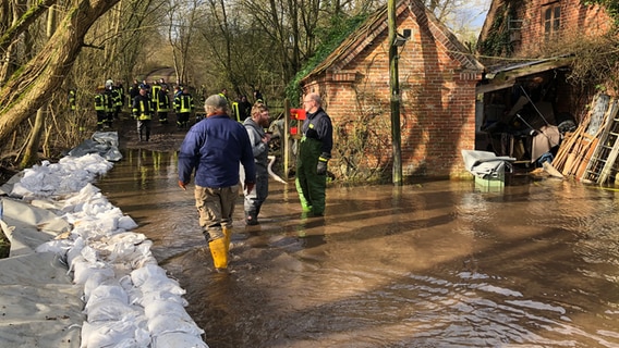 Bei einem Feuerwehreinsatz liegen Sandsäcke auf einem überschwemmten Grundstück in Helmstorf © NDR Foto: Stefan Corves